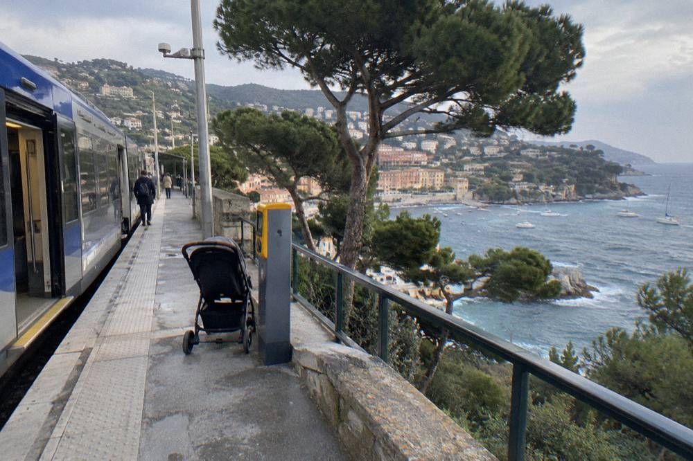 A small rail station platform above a Mediterranean coastline