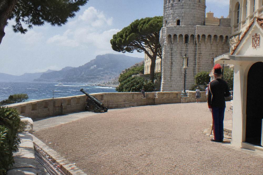 A stone palace square overlooking the Mediterranean with a fortified facade