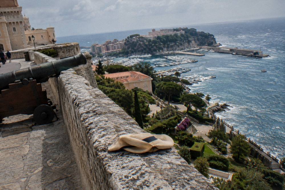 Stone ramparts and terraced walkway above Monaco harbor on a bright day